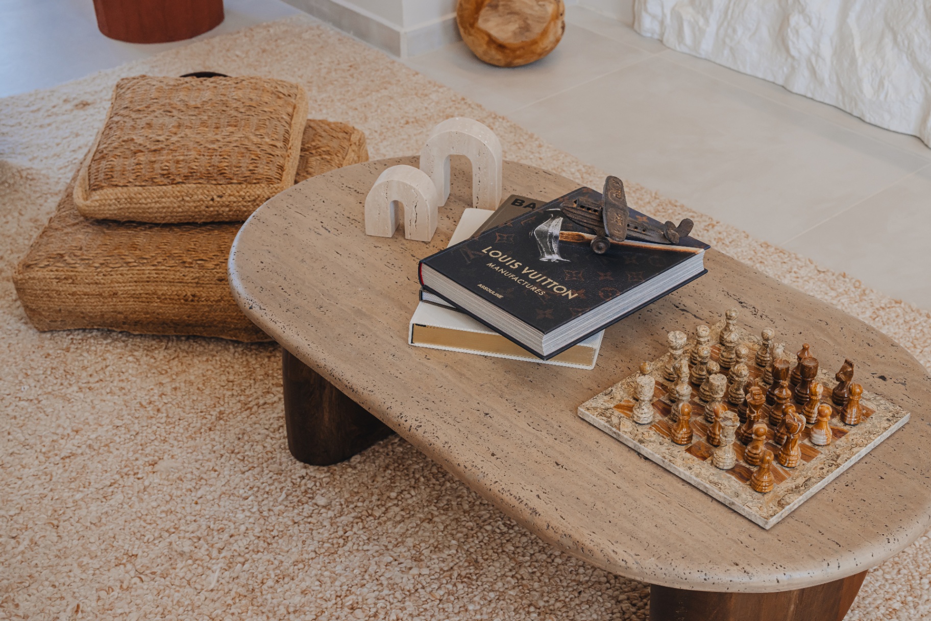 Travertine coffee table with chess set and rattan floor cushions