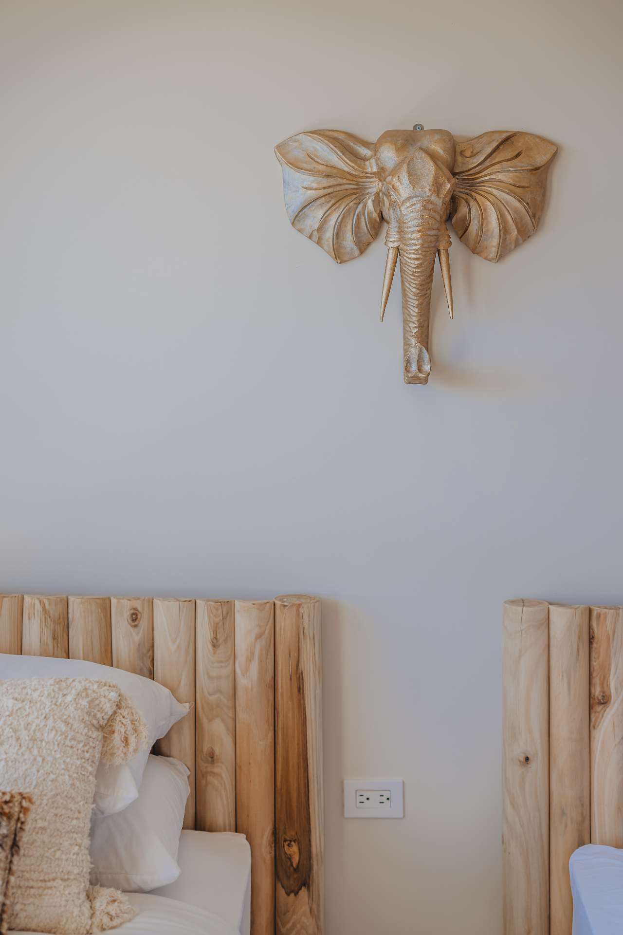 Bedroom detail with carved wooden headboards and gold sculpture
